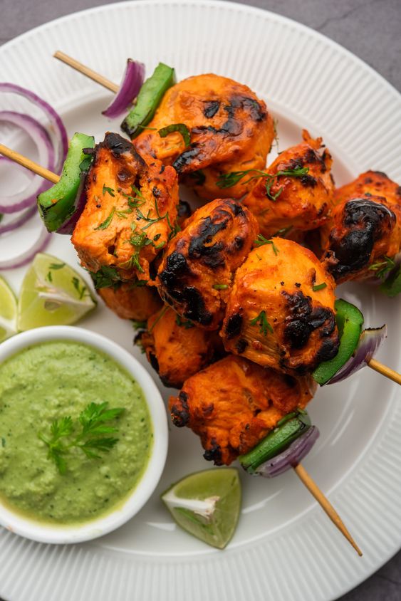 Indian chicken tikka kebabs, marinated in spices and yogurt and roasted in tandoor. served with green chutney and onion